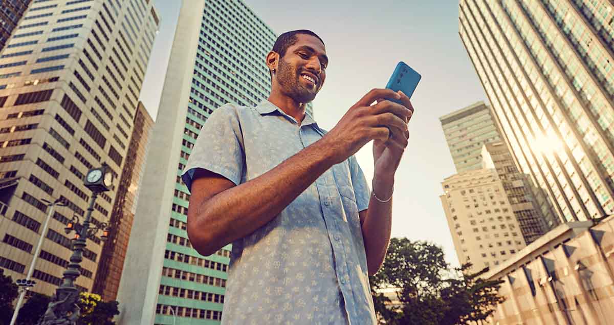 Homem feliz mexendo no celular