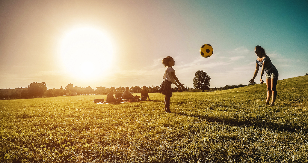 Família brincando com bola em parque ao ar livre