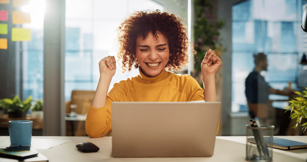 Mulher feliz em frente a computador